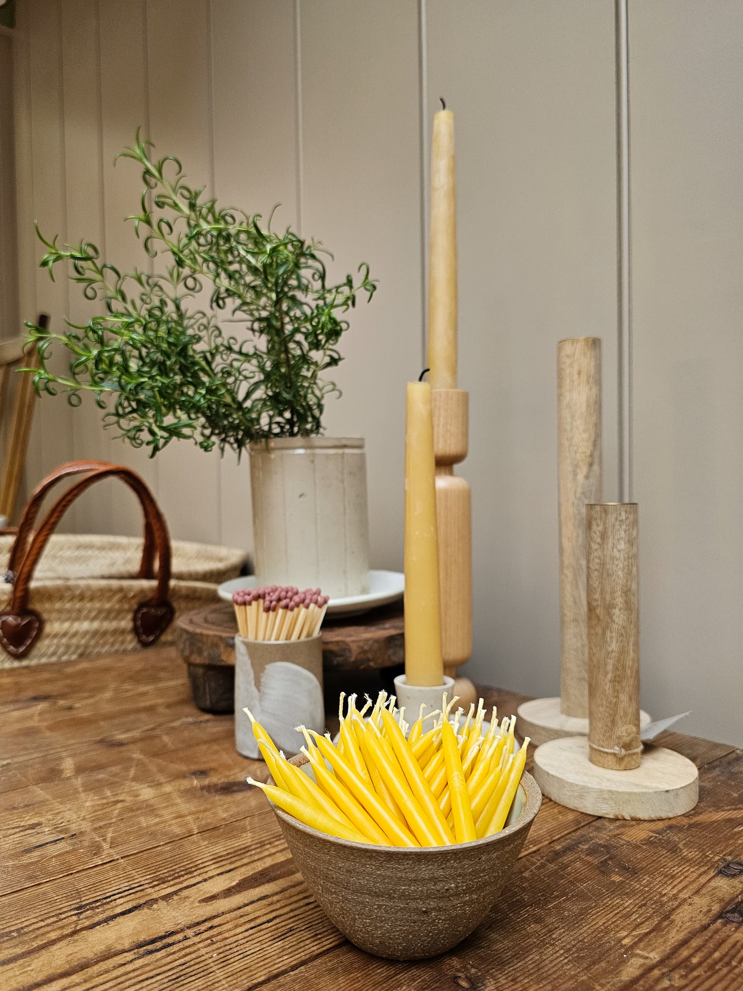 Multiple mini candles placed in a bowl on a table setting.