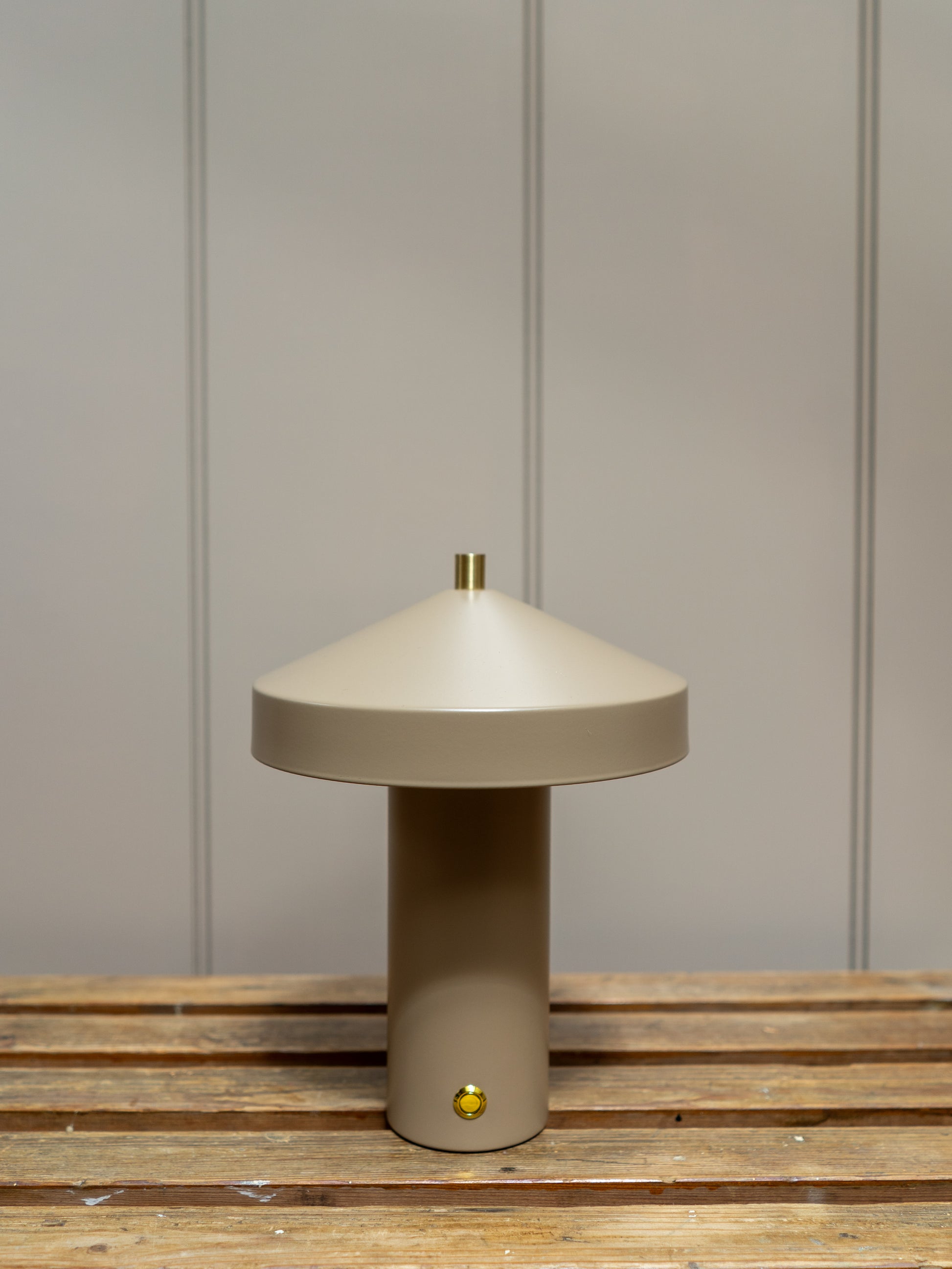 Beige table lamp on a wooden surface with a neutral wall background