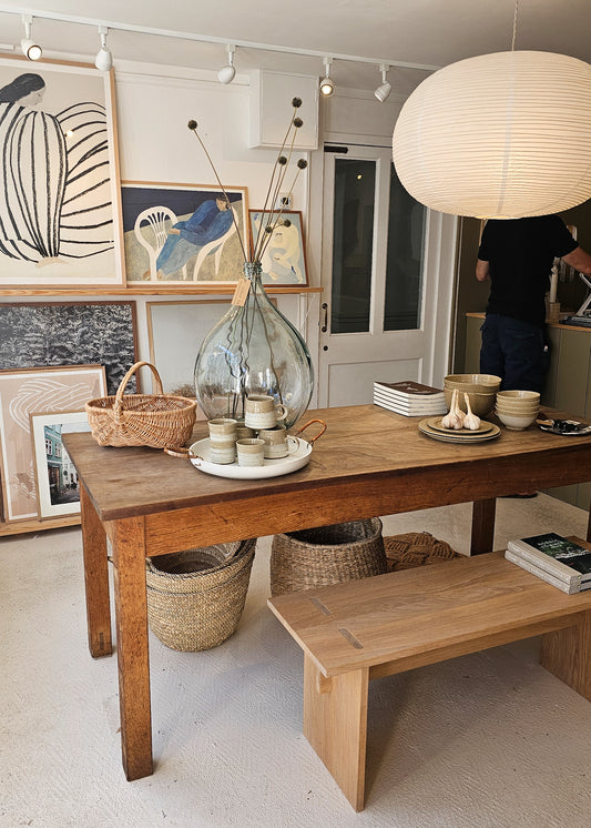 Wooden dining table with decor items in a room with framed art on the wall.