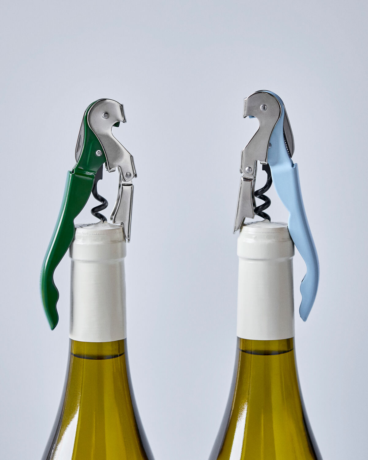 Nicolas Vahé waiter's friend bottle openers in green and light blue on wine bottles