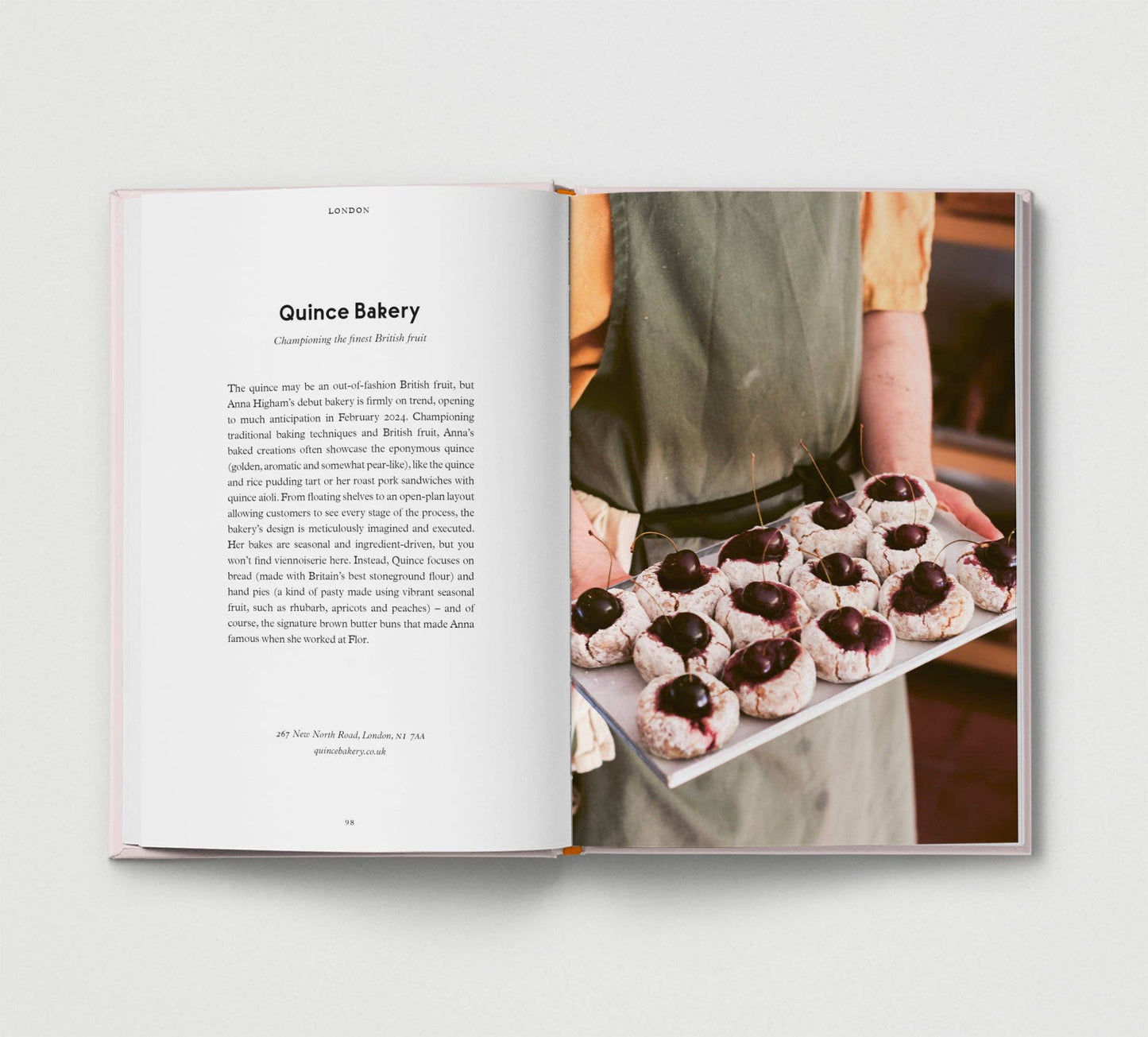 Open book showing a page with text and an image of a person holding a tray of pastries.