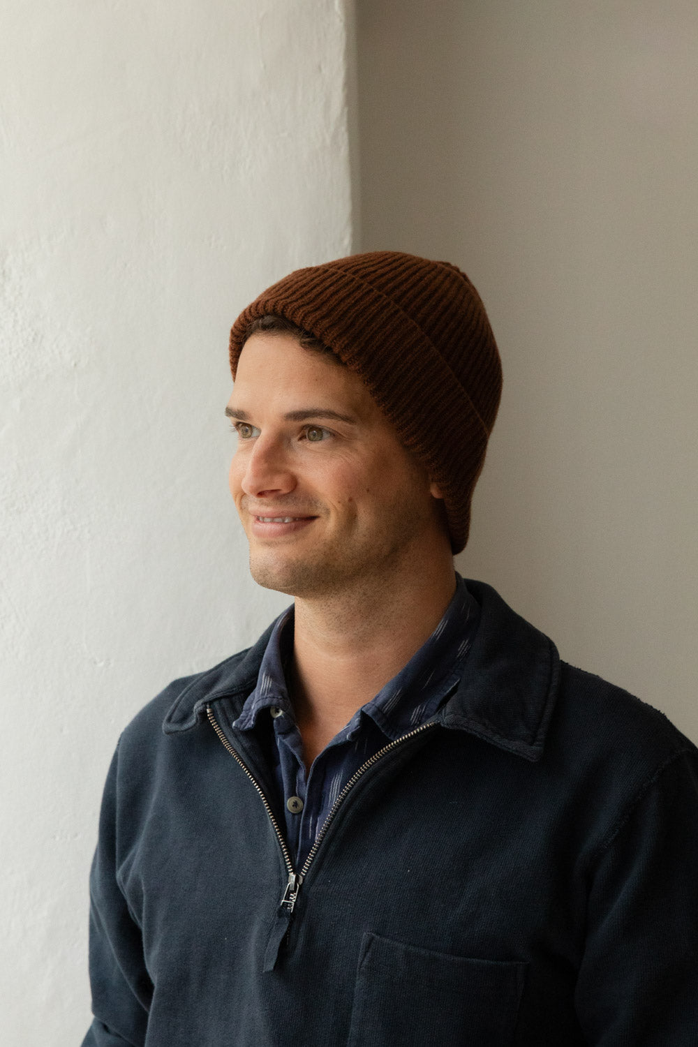 Man wearing a rich brown ribbed merino lambswool beanie