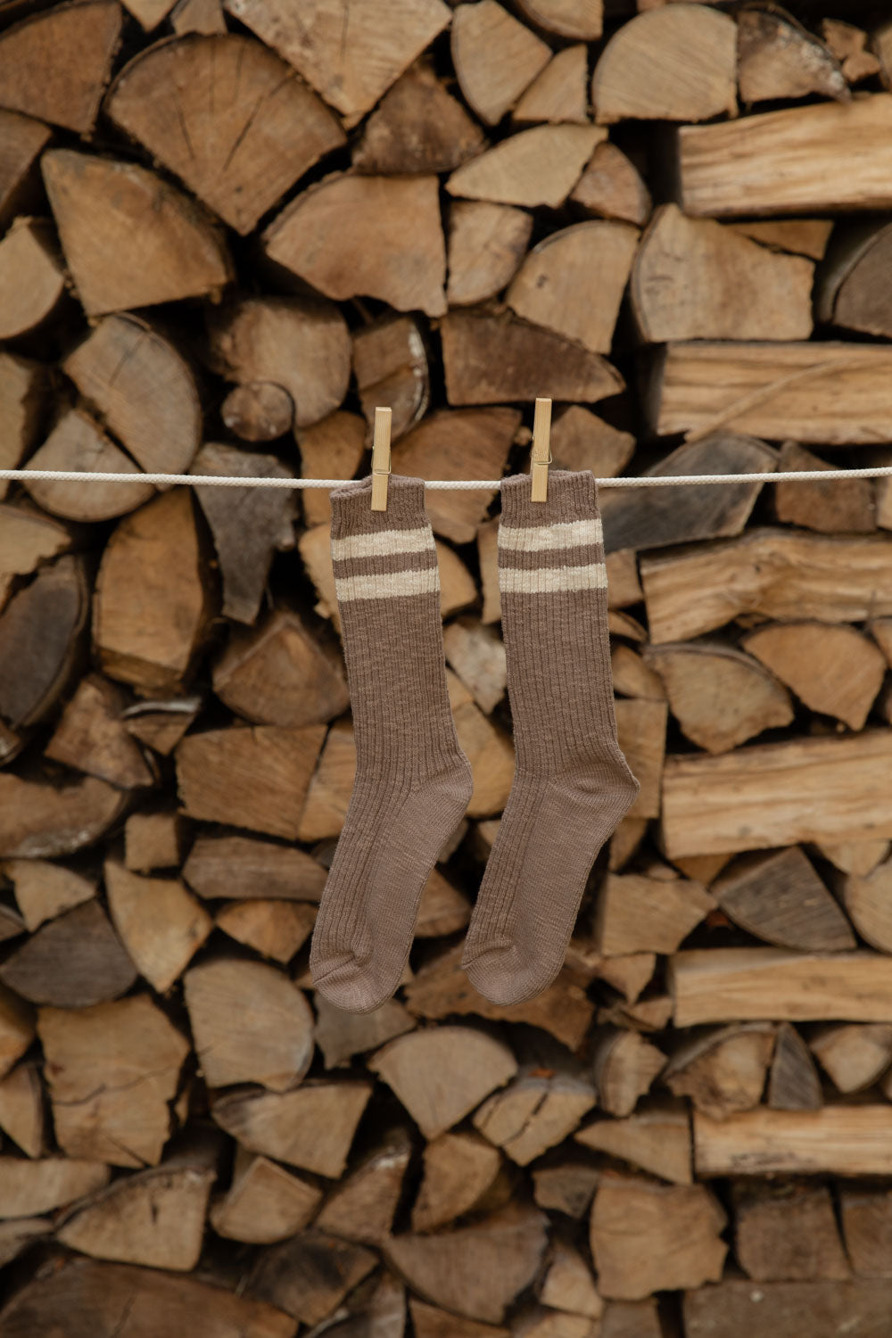 Le Bon Shoppe Cottage Socks in Varsity Stripe, brown with cream stripes, pegged on a line