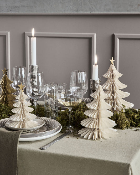 Ivory paper Christmas trees with gold star toppers styled on a festive dinner table