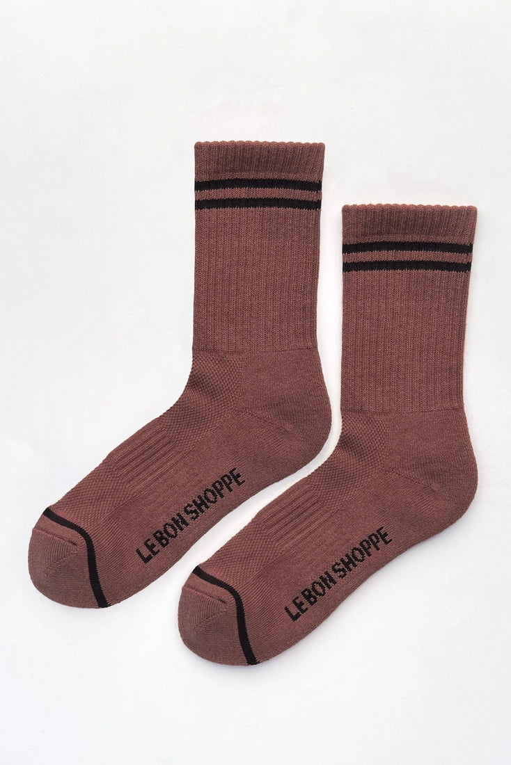 A pair of brown crew socks with black stripes at the ribbed cuffs, black toe caps, and black text reading 'LEBON-SHOPPE' printed on the soles, displayed on a clean white background.