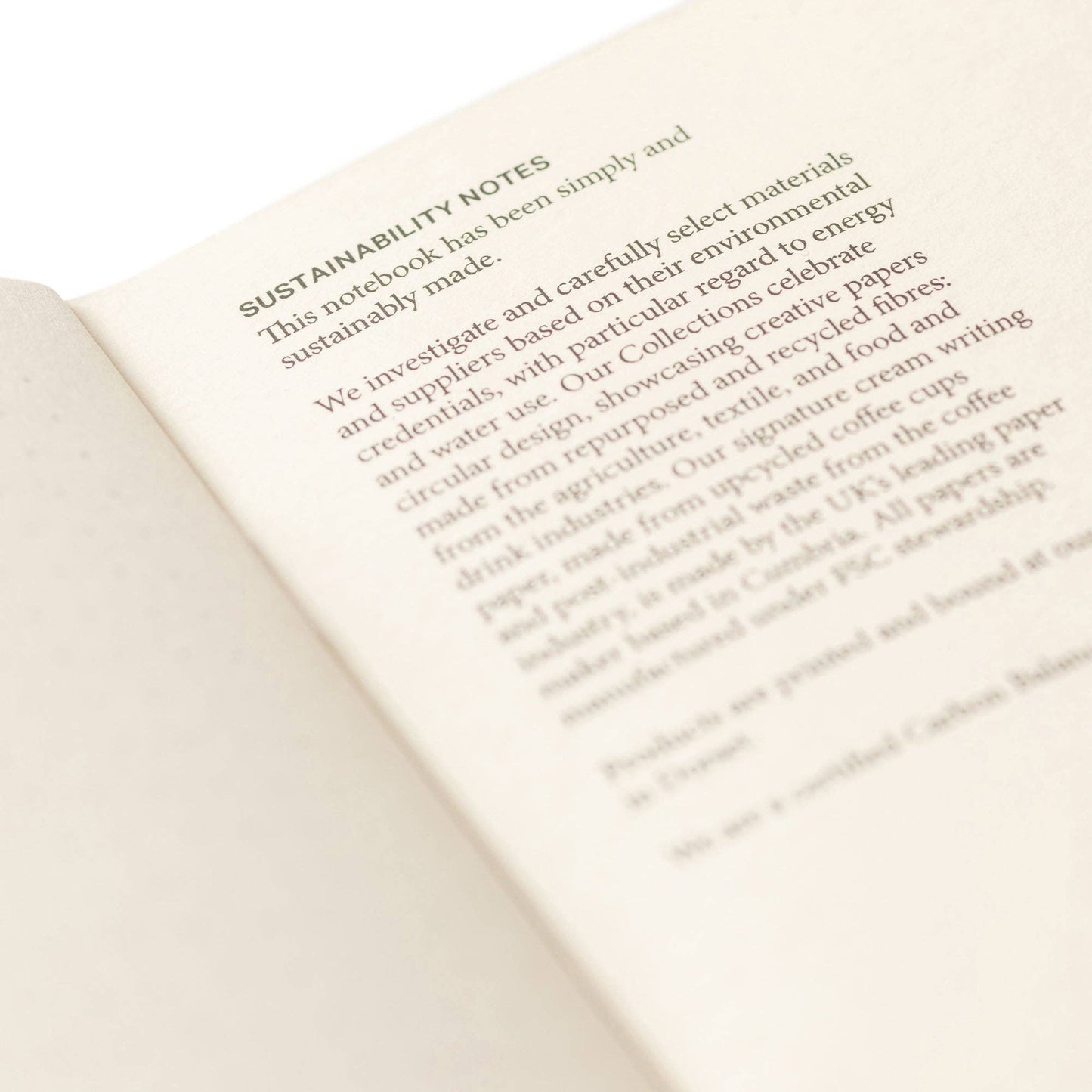 Open notebook with sustainability notes on a white background.