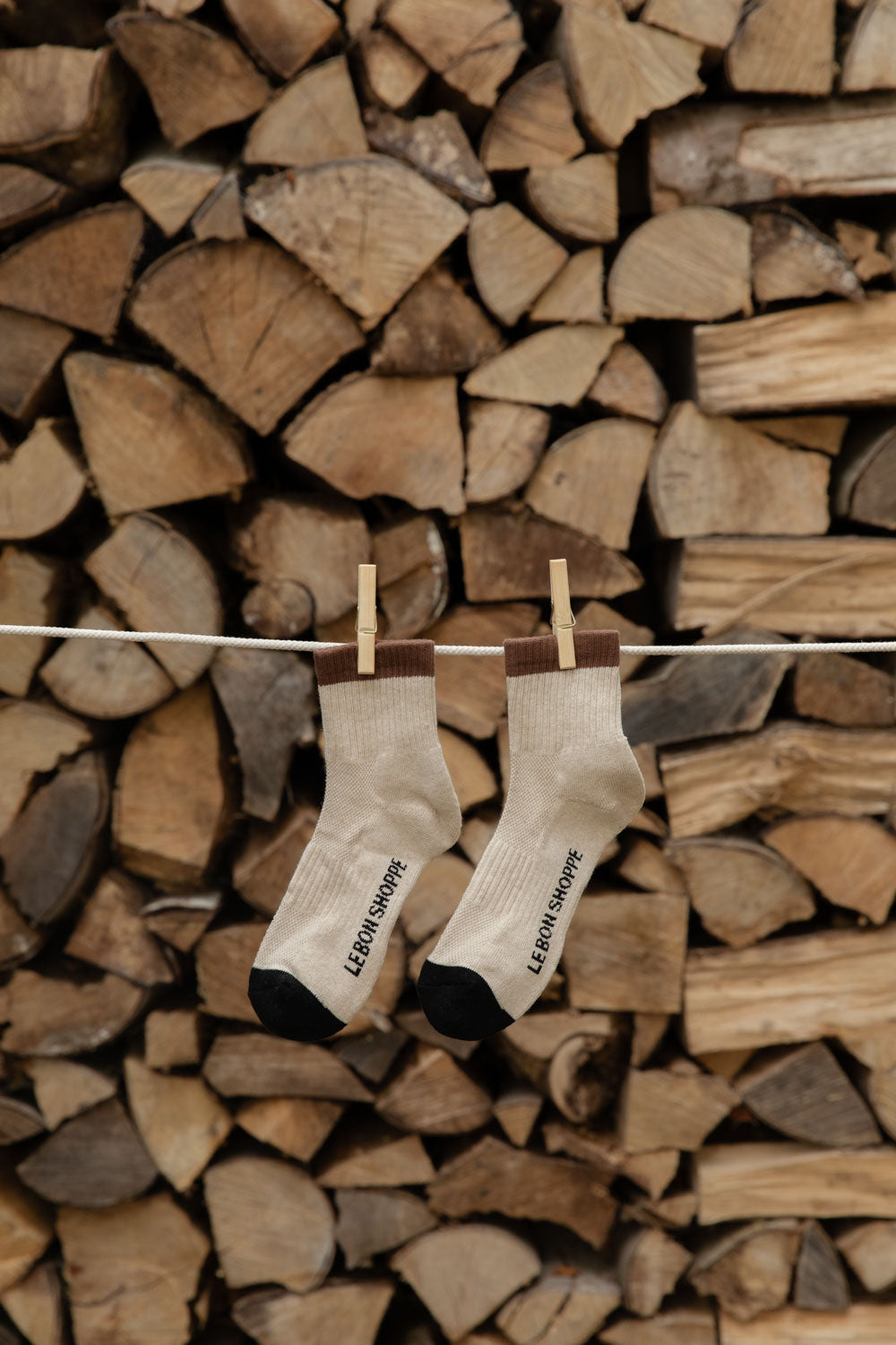 Le Bon Shoppe Girlfriend Socks in Black Coffee, cream with brown cuffs and black toes, pegged against logs