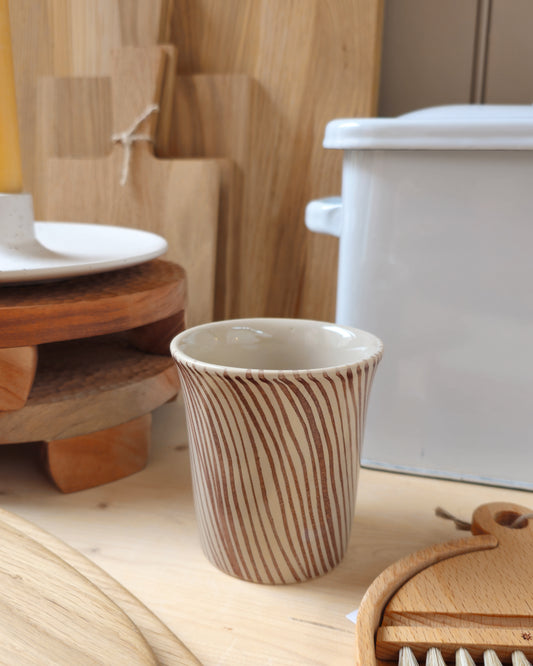 Diva mug with brown stripe pattern on a wooden kitchen shelf, styled in a kitchen setting with choppins boards, brushes, enamel bread bin and a candle.