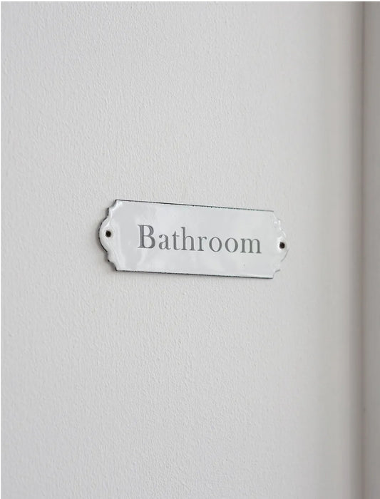 A rectangular enamel bathroom sign.