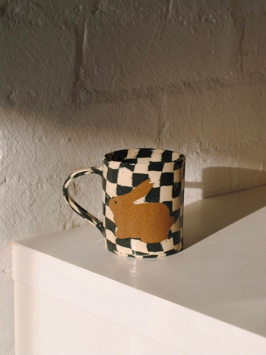 Fern Taylor Checkerboard Rabbit Mug in black and white with clay rabbit motif, handmade stoneware