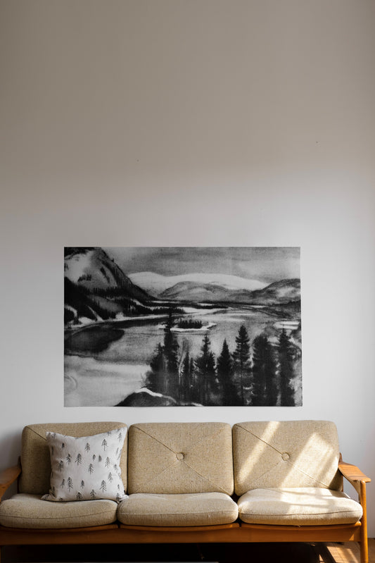 Sofa with a scenic black and white drawing of a mountain landscape on a wall.