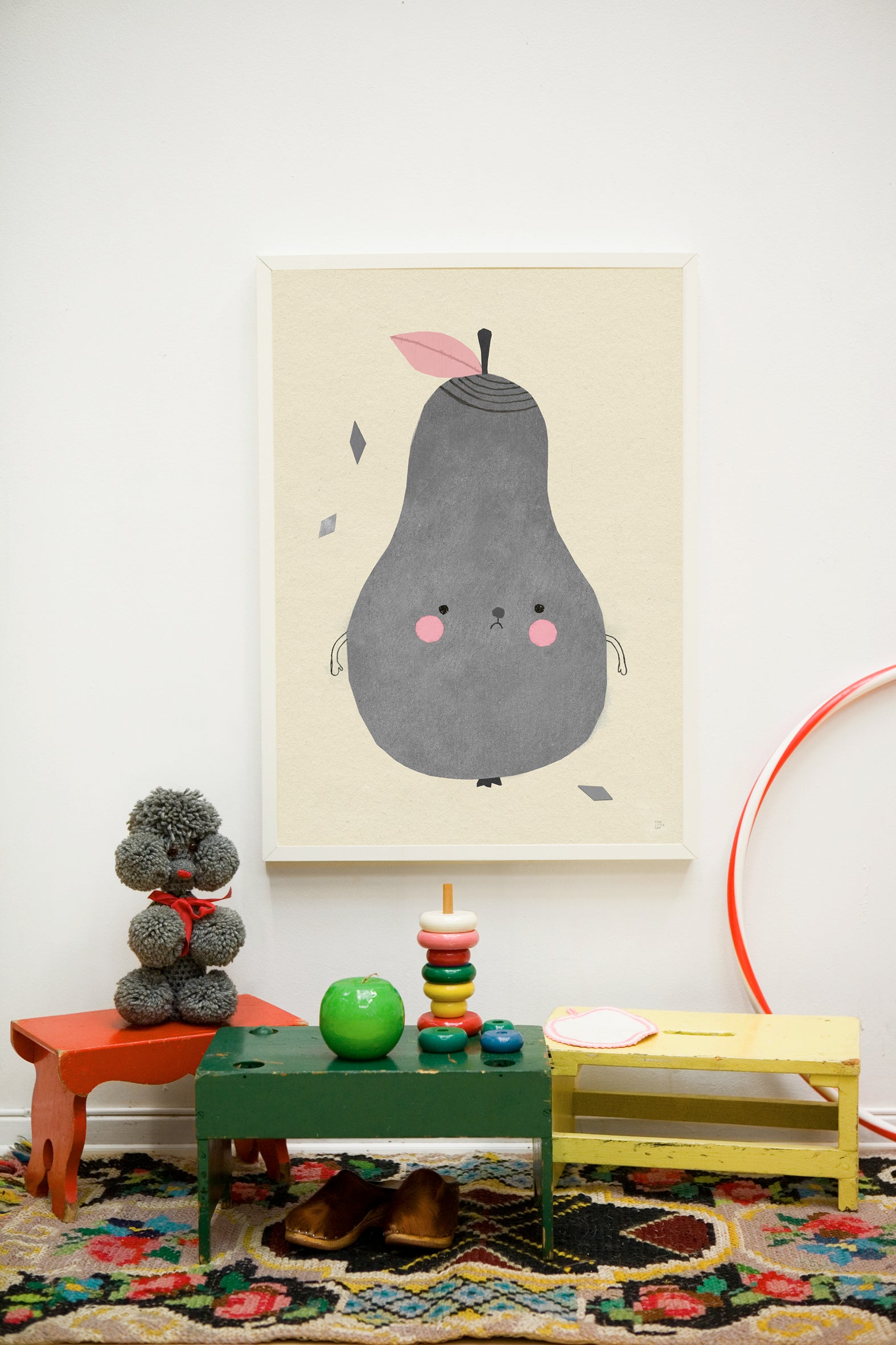 Children's room with a pear-shaped poster, colorful toys, and a rug.