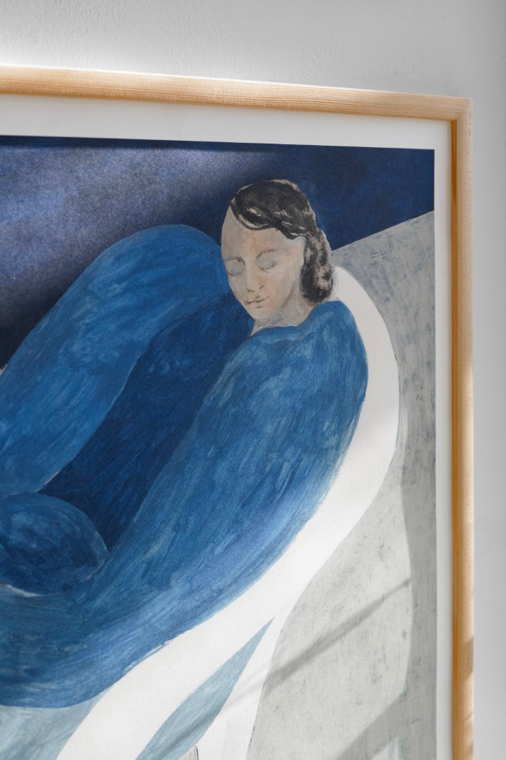 Close up of a poster featuring a blue figure lounging on a white chair.
