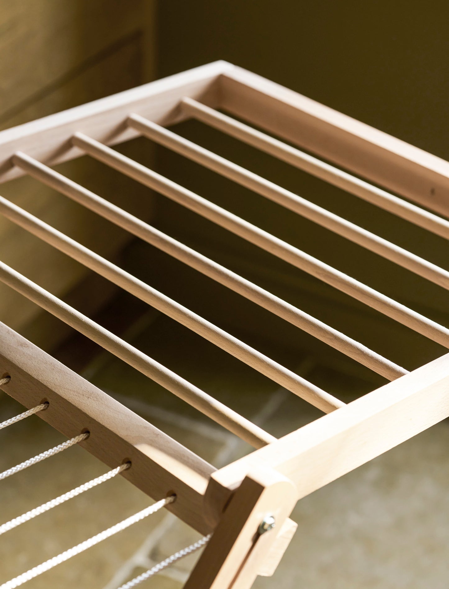 Close up of a Garden Trading Chalford Airer, made from raw Beech wood, displayed folded out in a neutral kitchen setting. 