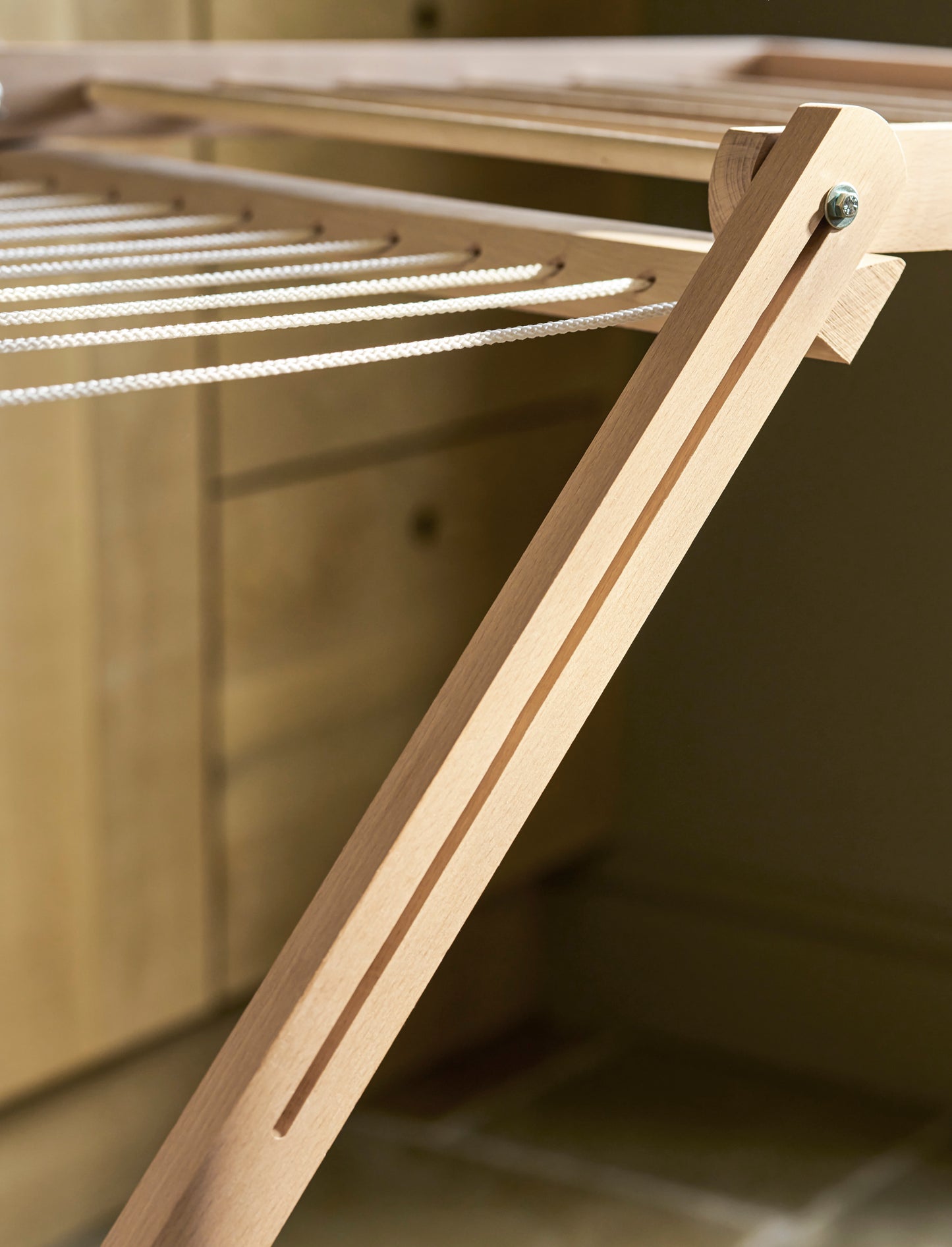 Close up of a Garden Trading Chalford Airer, made from raw Beech wood, displayed folded out in a neutral kitchen setting. 