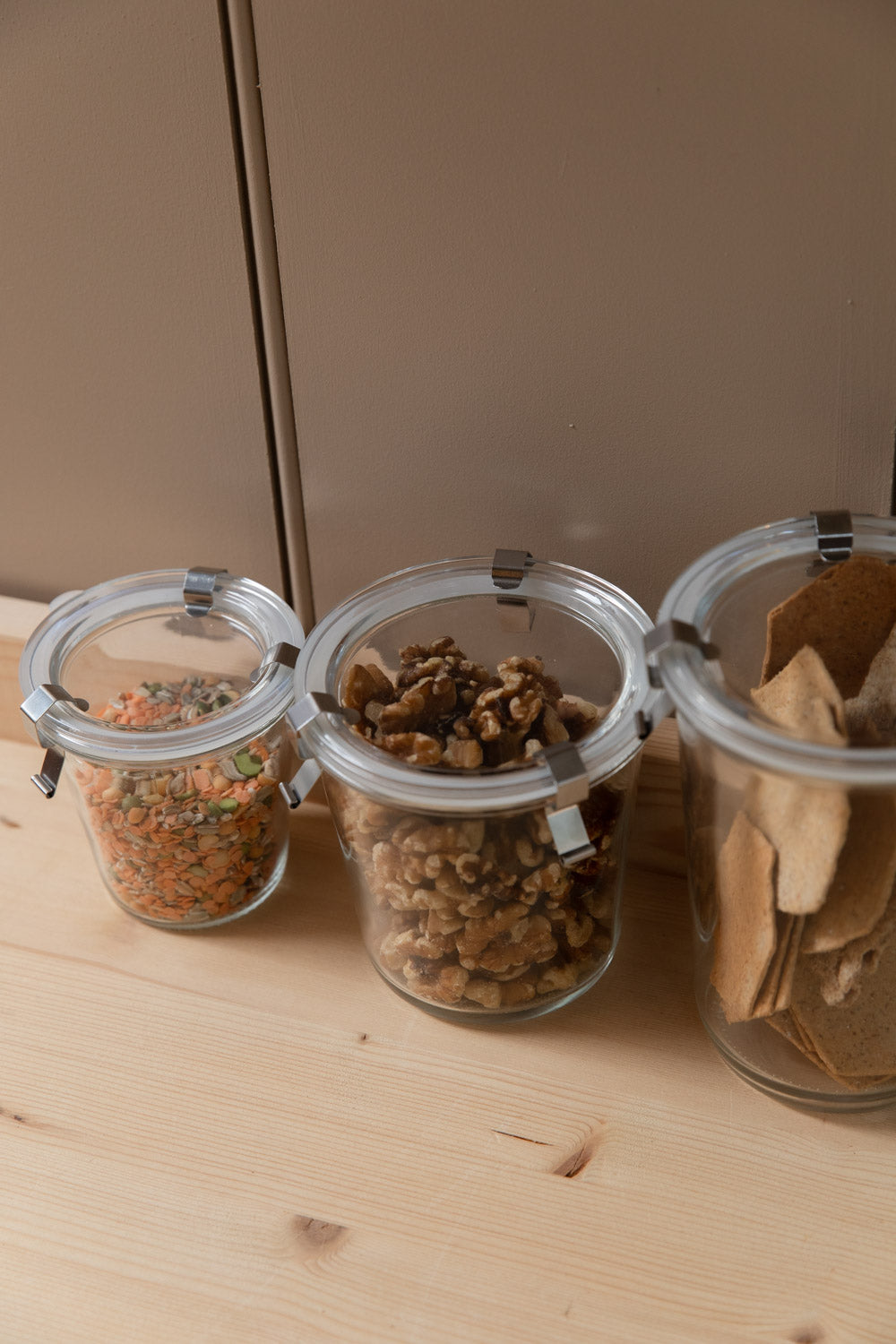 Close-up of glass storage jars with metal clips filled with pantry staples