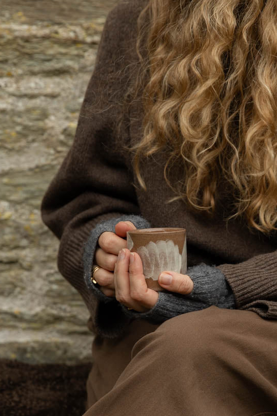 Small Brushstroke espresso mug held in both hands against a brown wool jumper