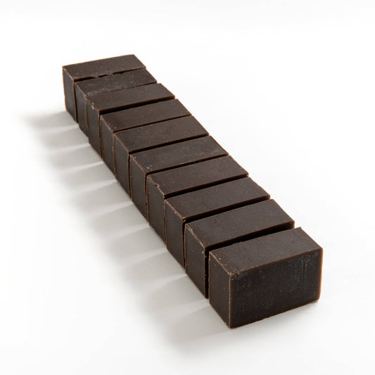 Row of hemp and walnut soap brick cut into smaller pieces on a white background