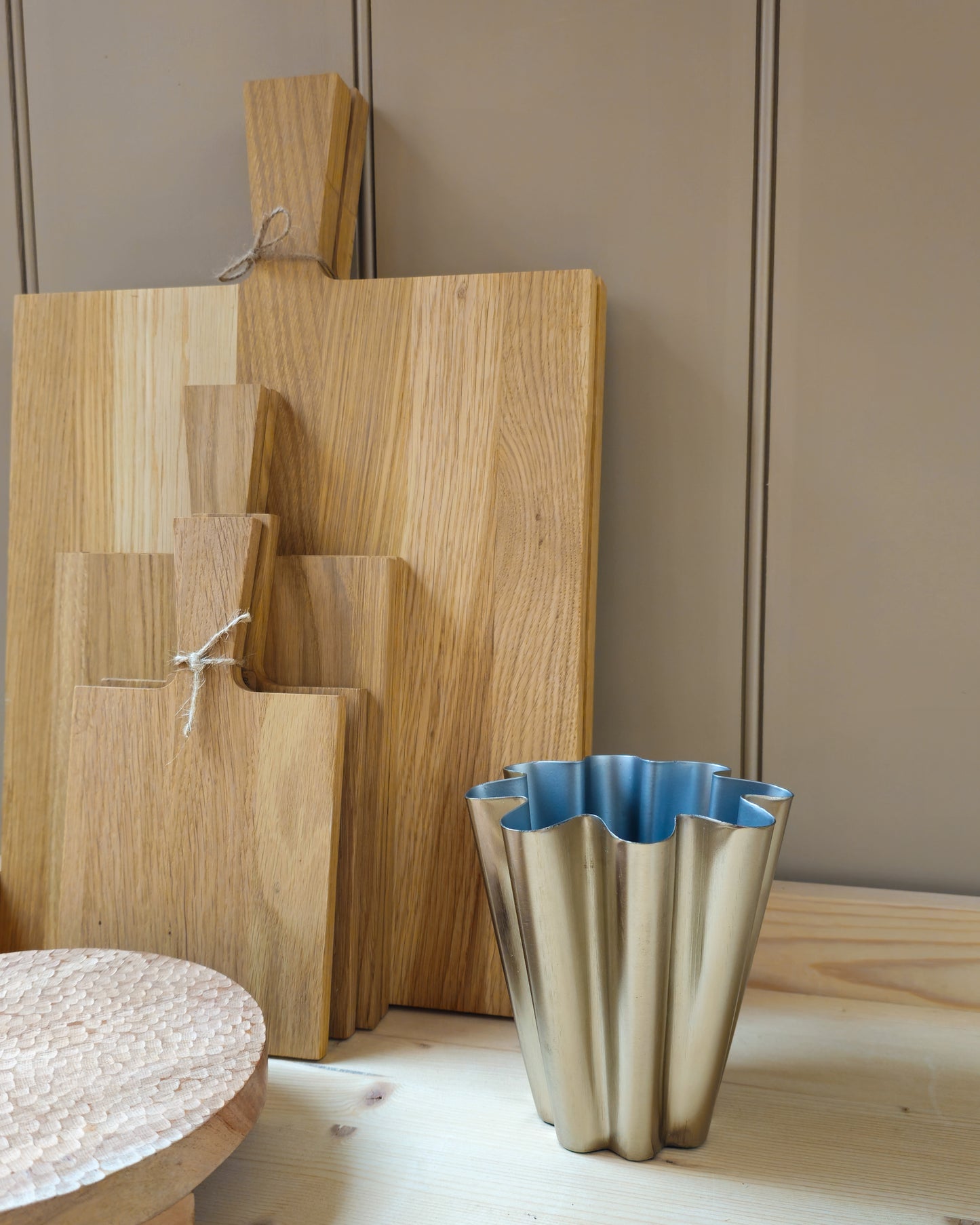 Close up of House Doctor Flood small brushed silver vase next to wooden oak chopping boards.
