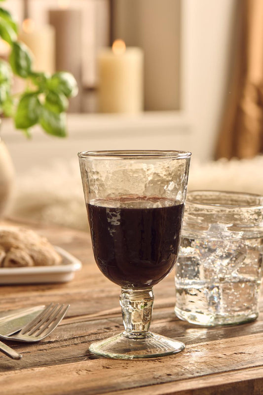 Glass of red wine on a wooden table with a blurred background