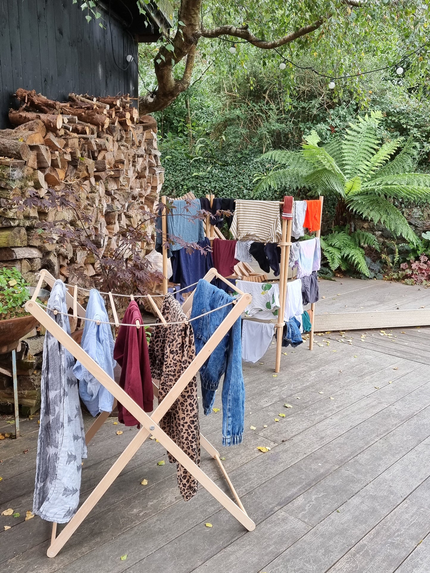 Foldable wooden wash drier airer with clothes drying on it, placed in garden.