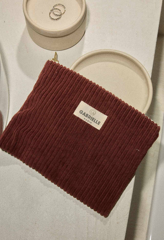 Red-wine coloured ribbed velvet pouch with a Gabrielle Paris label on a light background.