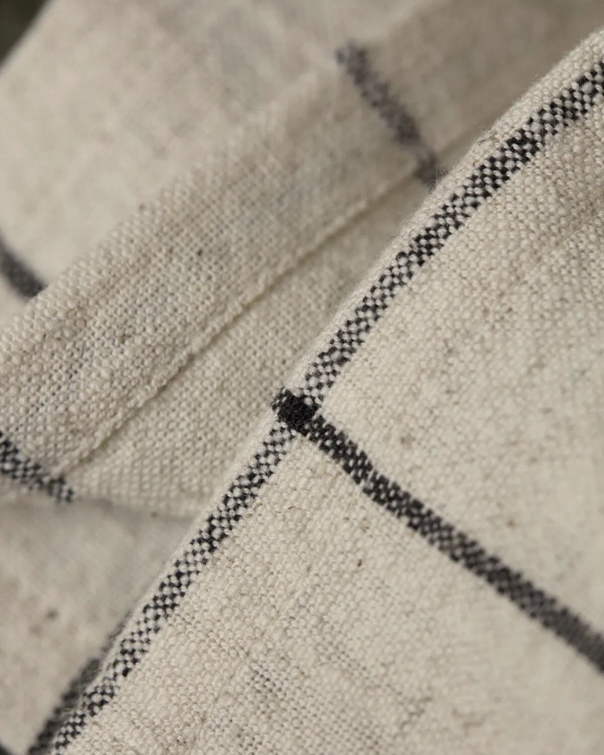 Close up of the Join, off-white and black check table runner, showing the texture and colour.