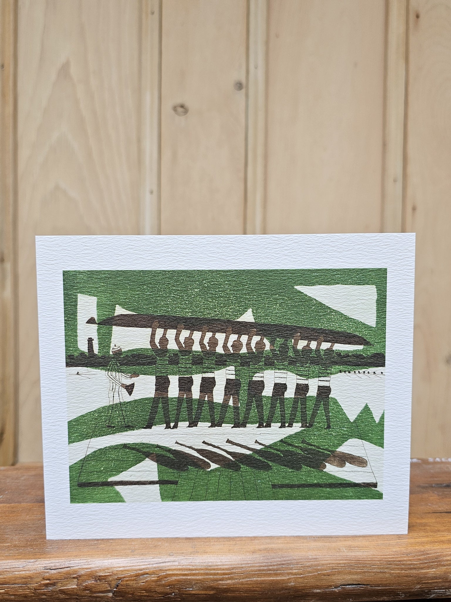Greeting card reproducing Julian Trevelyan's linocut print The Rowers, showing a rowing eight carrying their boat above their heads in a bold green and brown composition