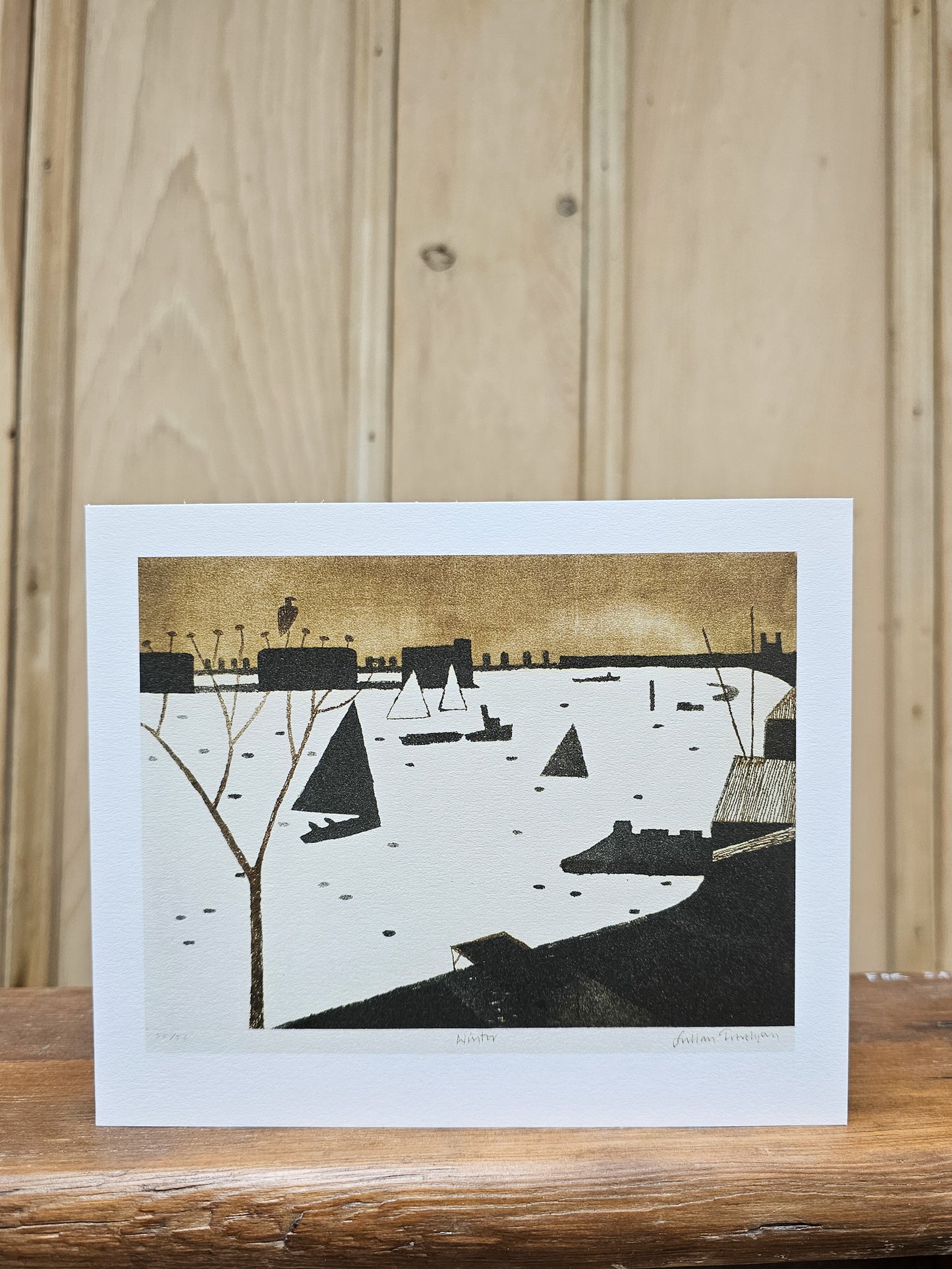 Greeting card reproducing Julian Trevelyan's 1974 print Winter, showing sailing boats on a frozen or misty river with a golden sky and dark industrial skyline