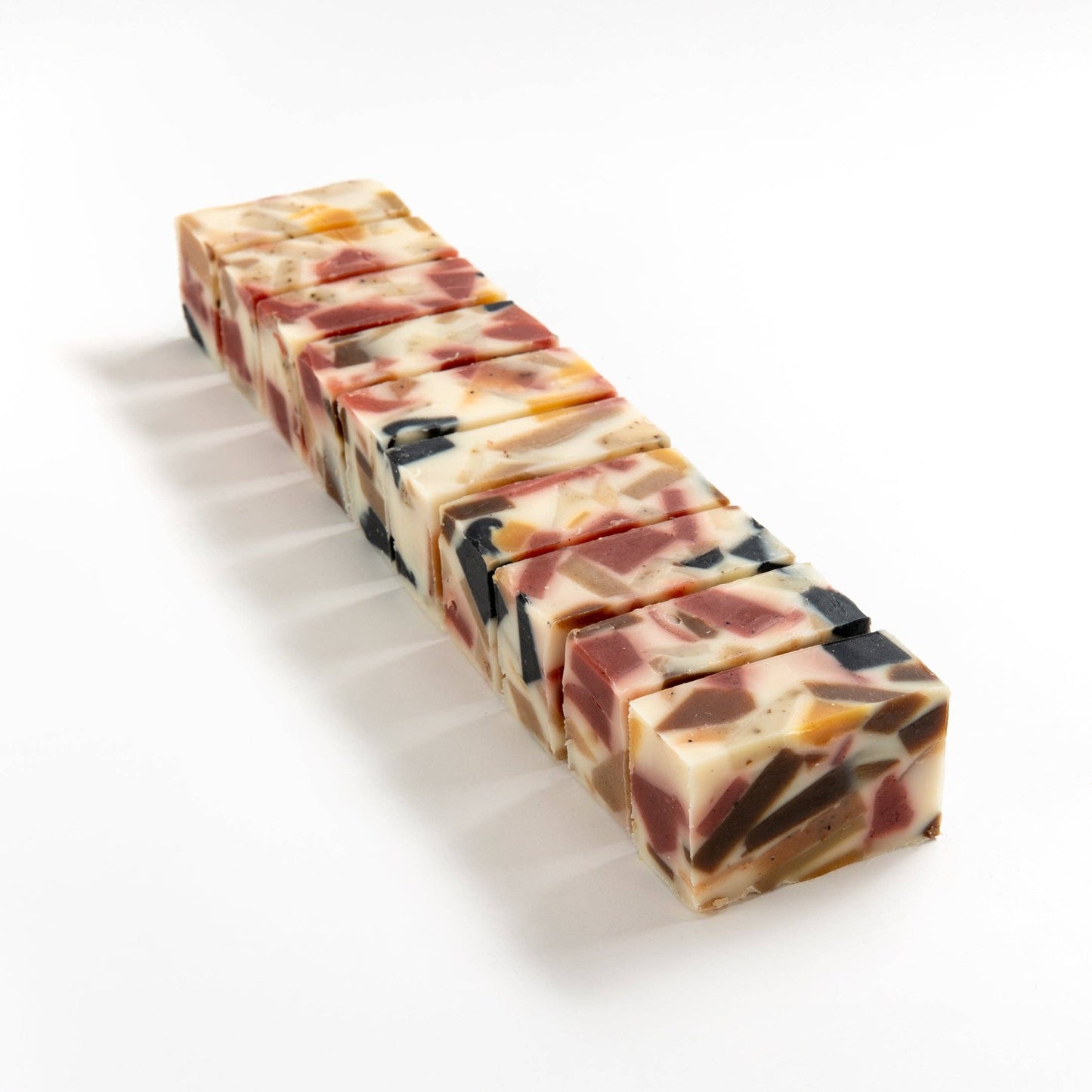 Row of kaliedosoap soap brick cut into smaller pieces on a white background.