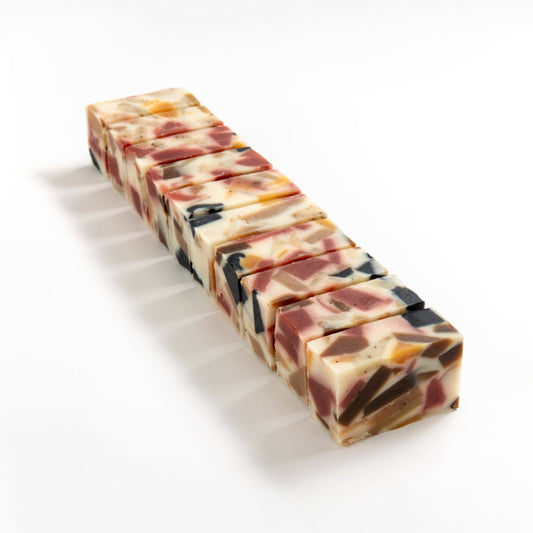 Row of kaliedosoap soap brick cut into smaller pieces on a white background.
