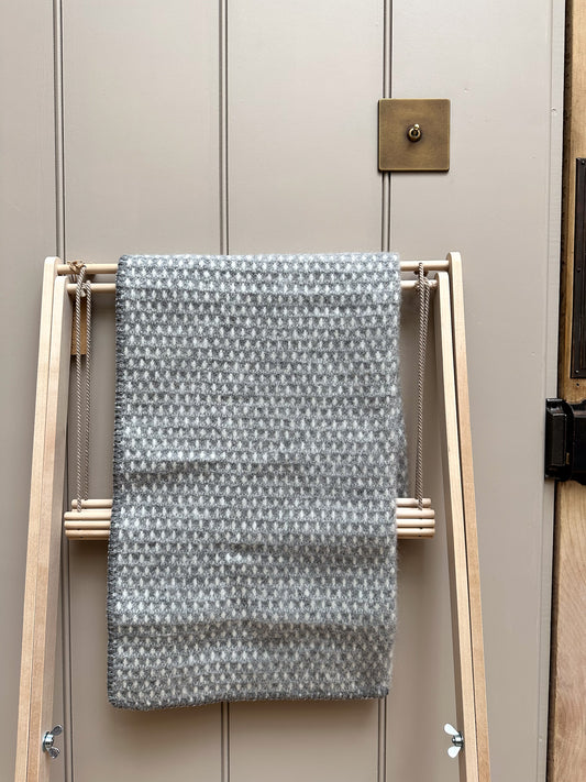 Klippan Knut Lambswool baby draped over a wooden clothes airer.