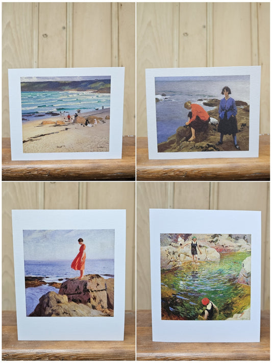 A collection of four Art Angel greeting cards reproducing paintings by Laura Knight, showing Sennen Cove beach, two women on coastal rocks, a woman in a red dress on a clifftop, and children paddling in a rock pool