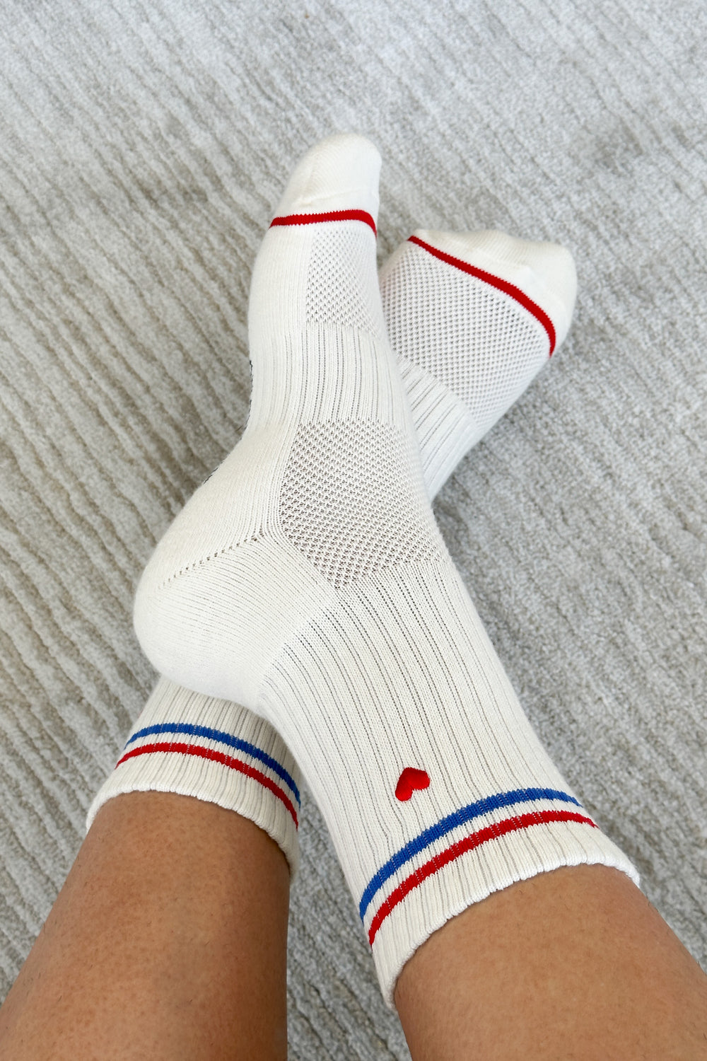 Crossed over feet on a grey background wearing Le Bon Shoppe Boyfriend Sock in the embroidered white/blue/red colourway.