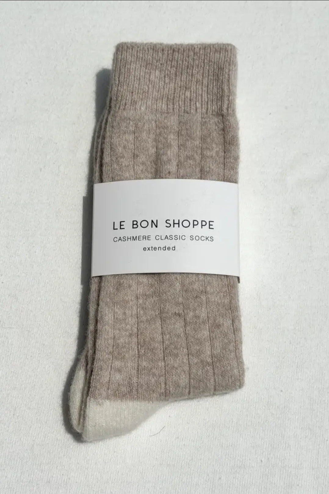 Packaged cashmere socks with 'Le Bon Shoppe' label on a light grey background.