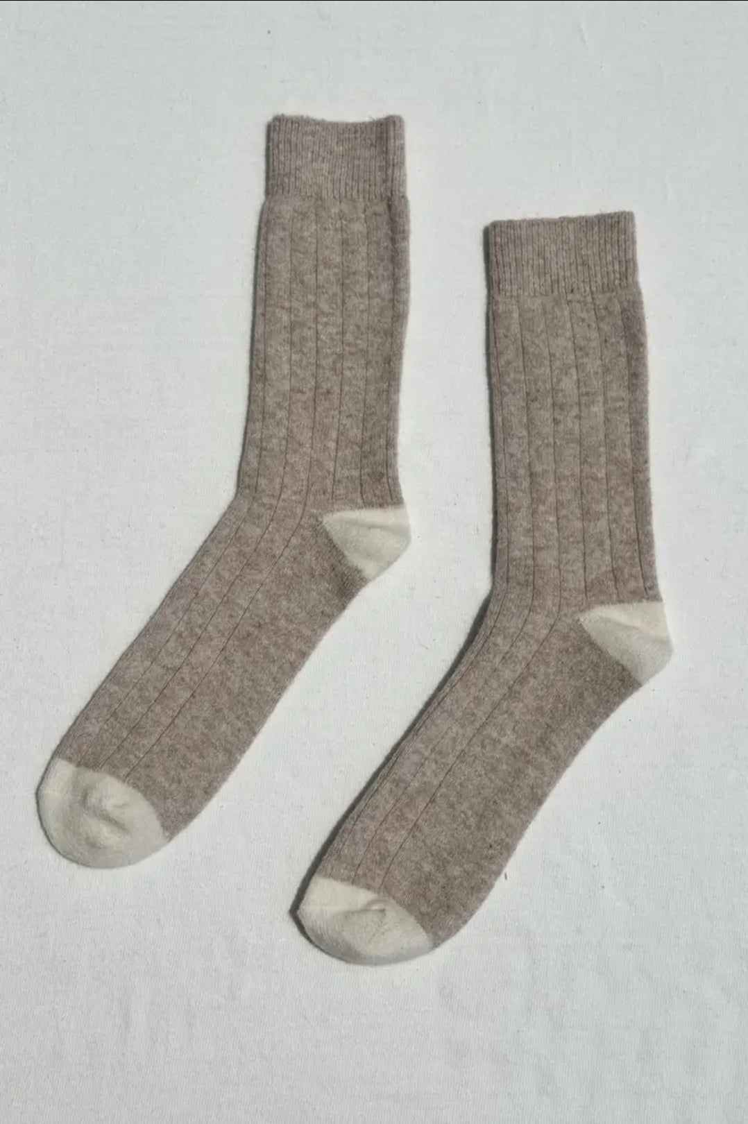 Pair of fawn socks on a light grey background.