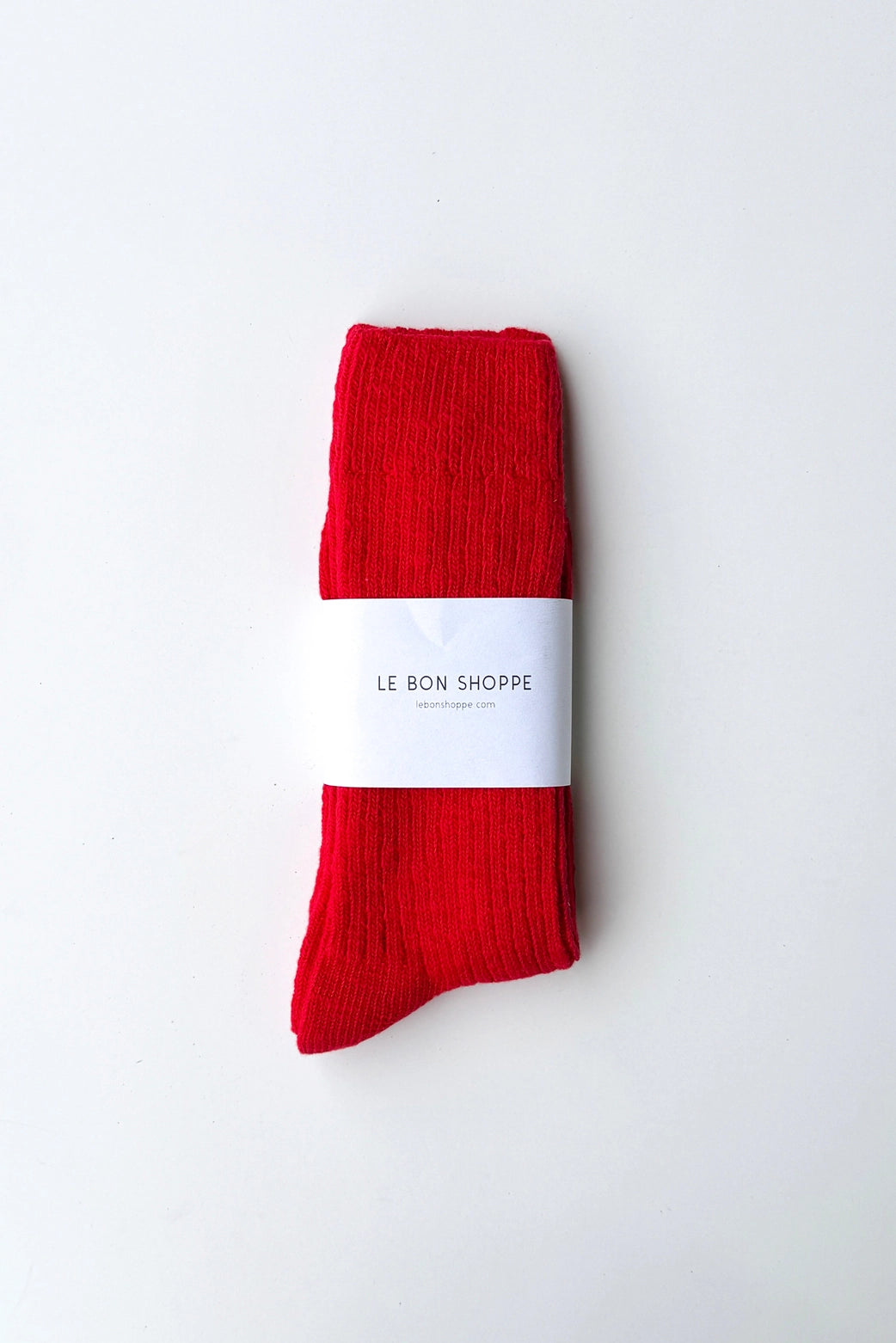 Le Bon Shoppe Cottage Socks in Chilli red open-knit cotton against firewood