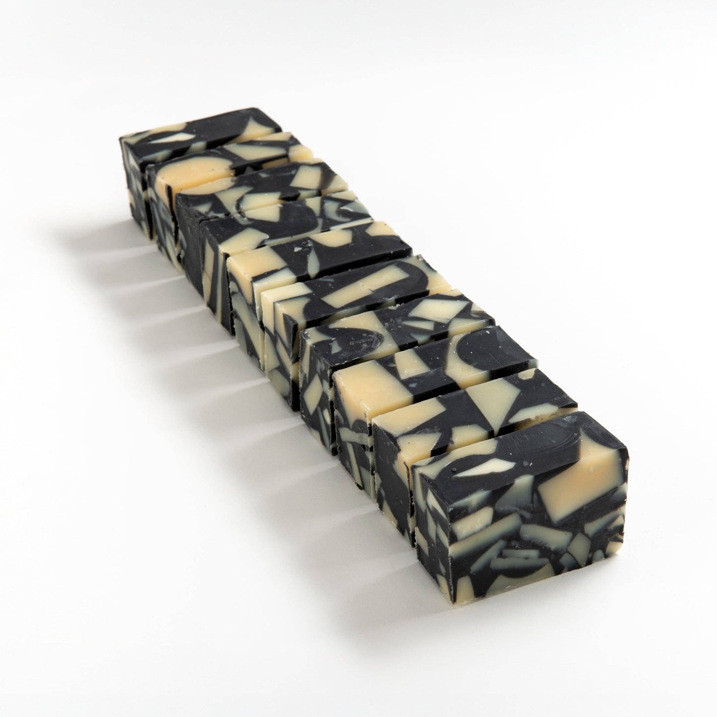 Block of monochrome soap brick cut into smaller pieces on a white background.