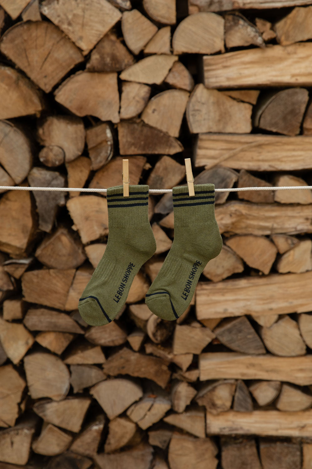 Le Bon Shoppe Girlfriend Socks in Sage with black stripes hanging on a line
