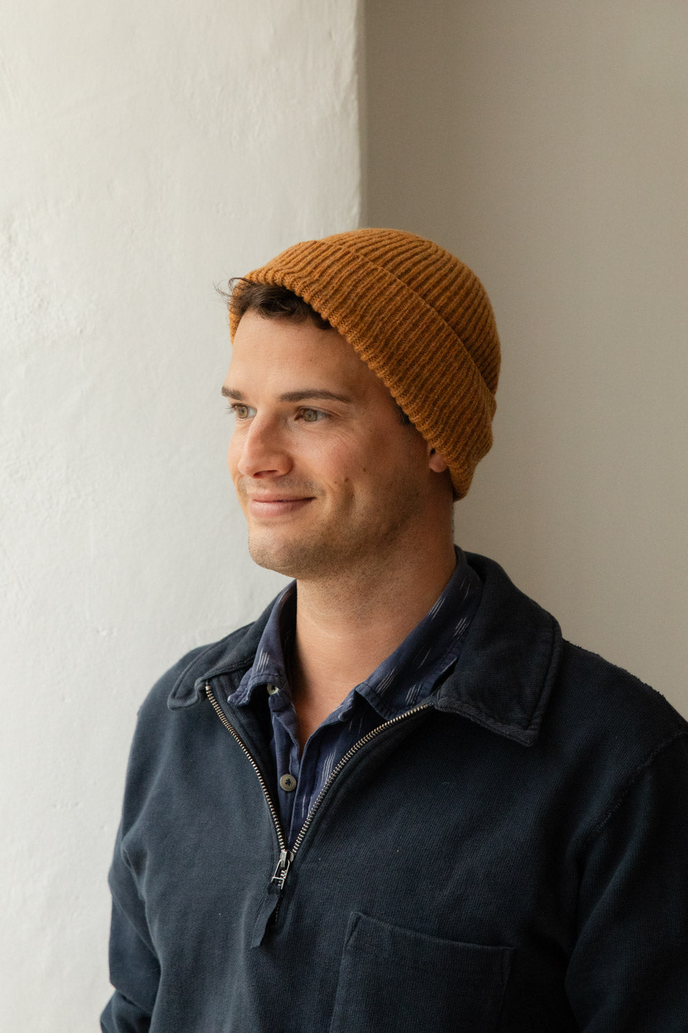 Man wearing a goldcrest orange ribbed merino beanie