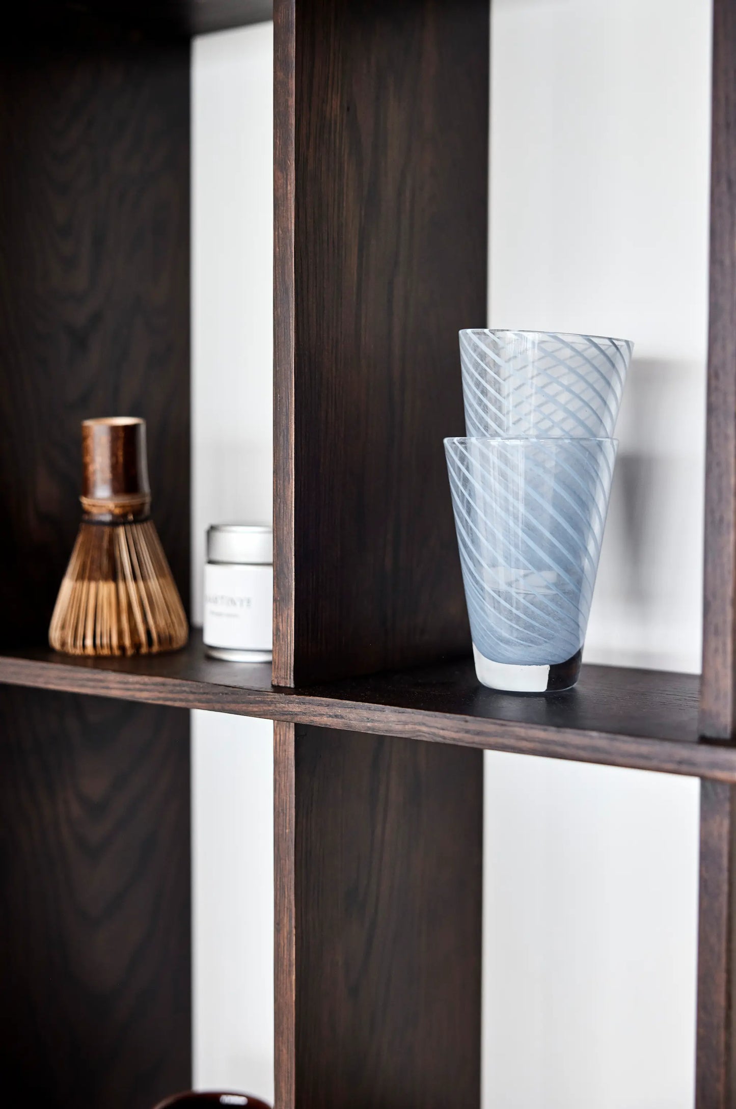 OYOY Grid Shelf in dark ash with blue ribbed glass vases and bamboo matcha whisk styled on shelves