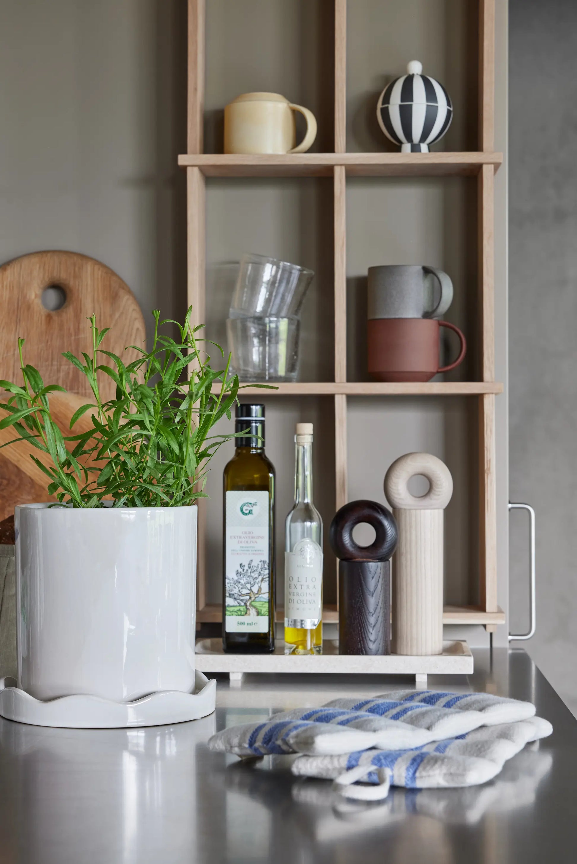 OYOY Grid Shelf in solid oak styled in kitchen setting with mugs, glassware and ceramics on shelves