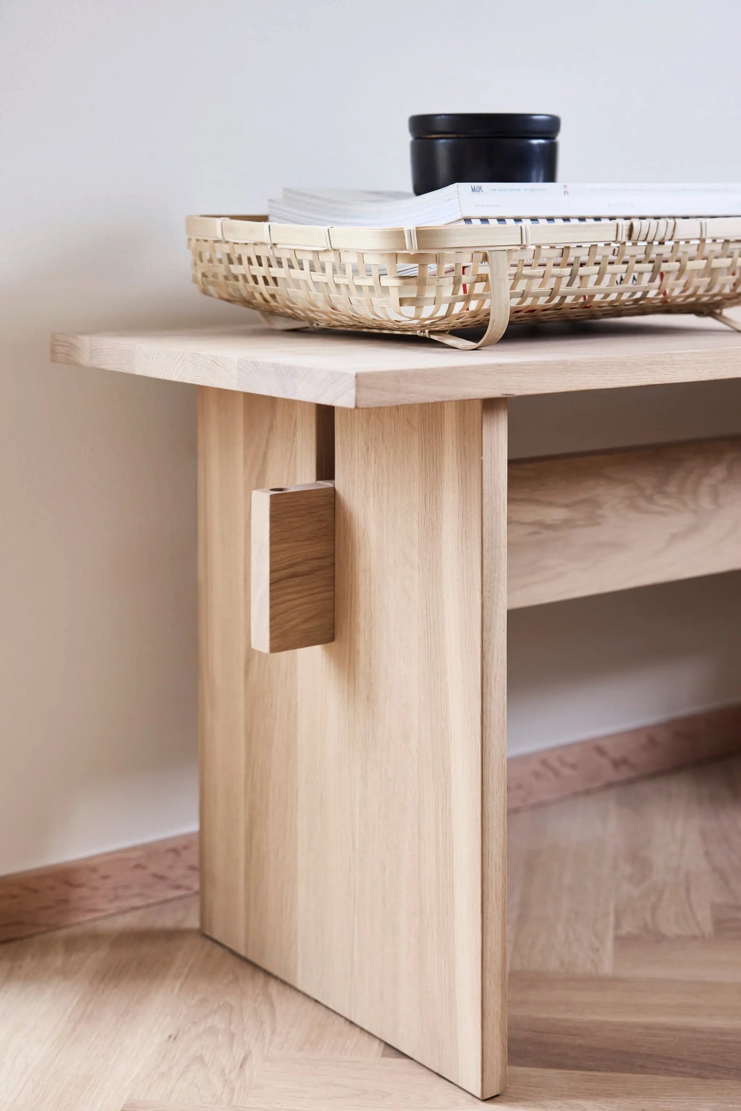 OYOY Kotai Bench in solid oak close up showing joinery detail, styled with rattan tray and books