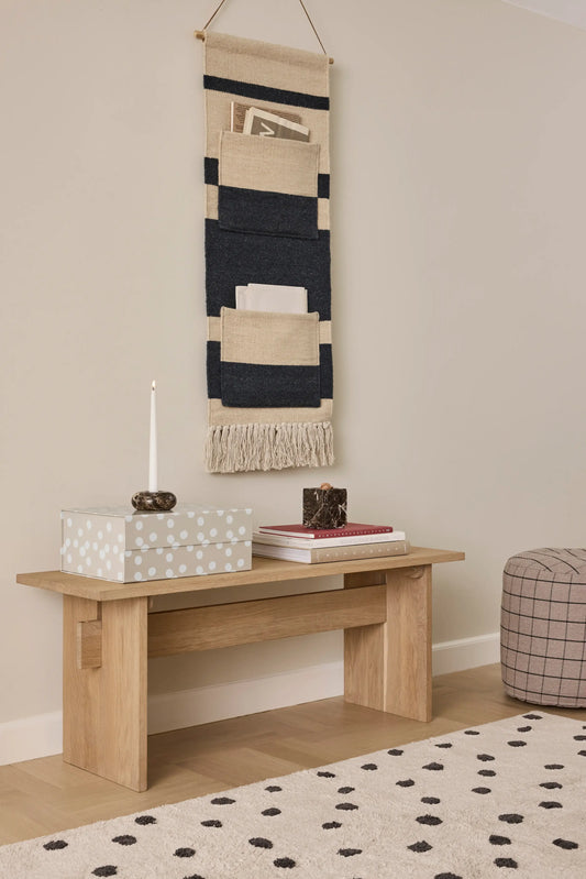 OYOY Kotai Bench in solid oak in living room setting with books, candle and wall-hung textile organiser above