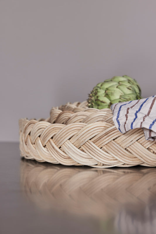 OYOY Maru Bread Basket in rattan close up with braided edge, artichoke and striped linen cloth