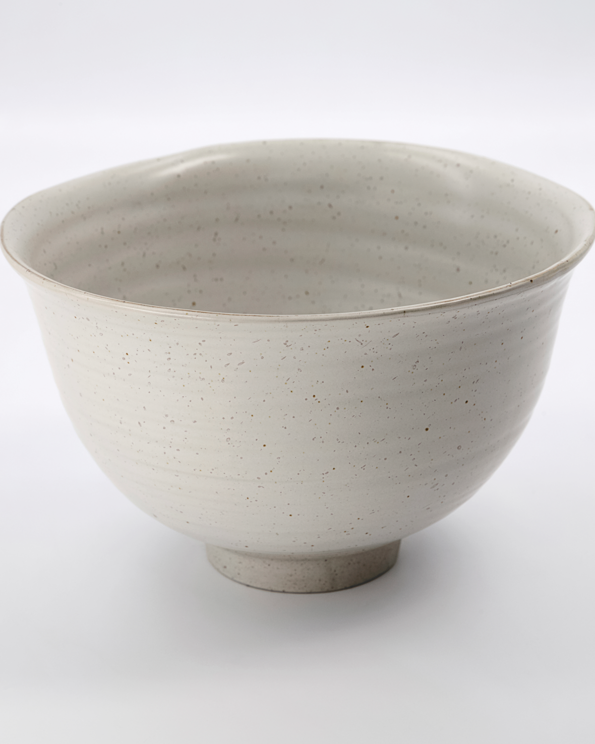 Speckled white stoneware serving bowl on a white background.