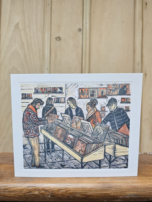 Illustrated card of people shopping in a  record store with a wooden background