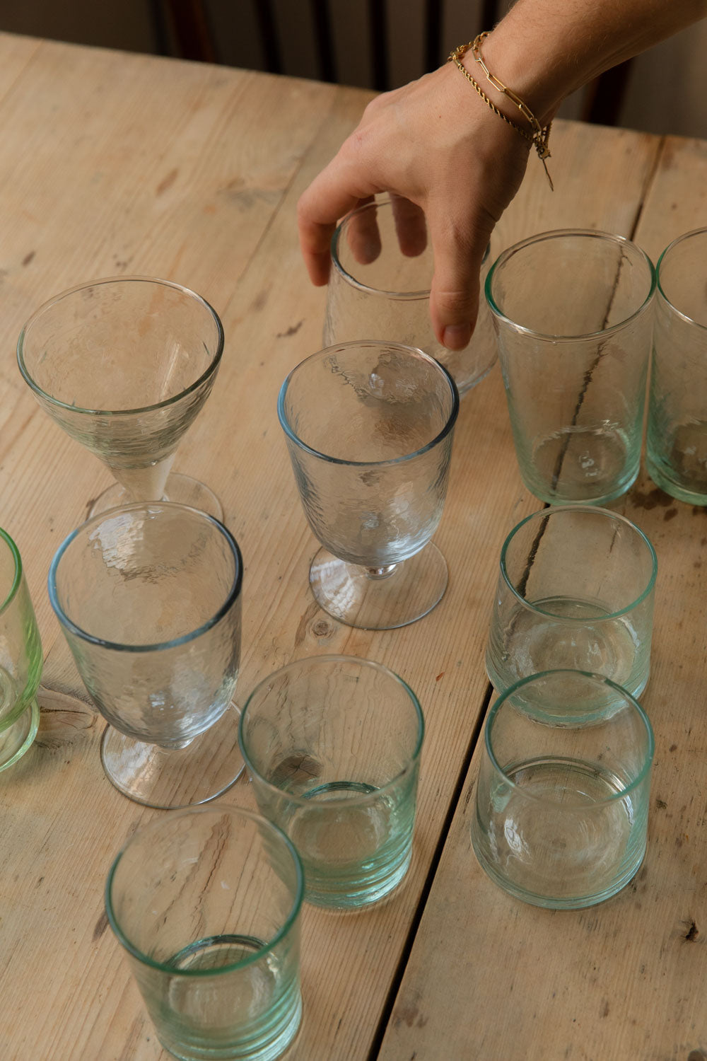 Meknes recycled glass tumblers grouped with hammered and cut line glasses on a pine table
