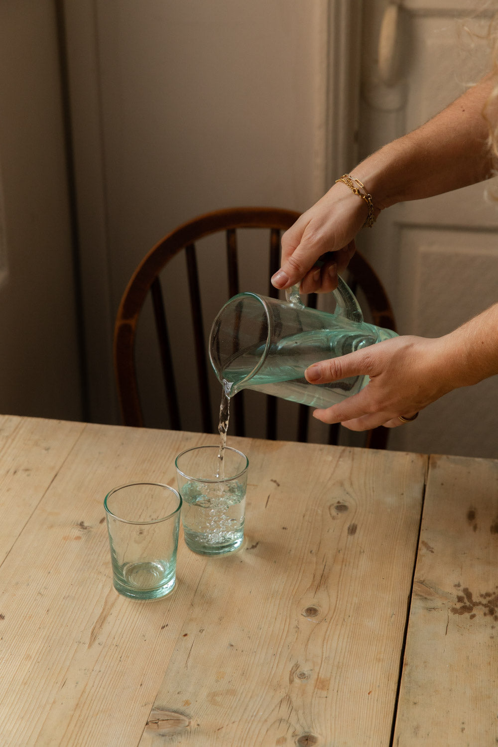 Pouring water from a Meknes recycled glass jug into a matching tumbler