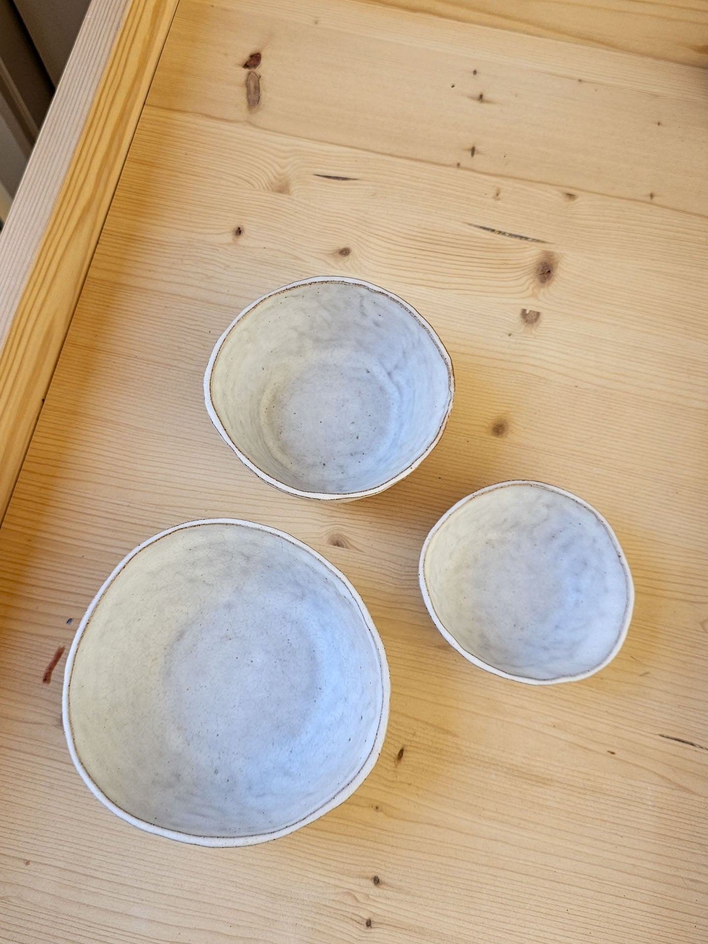Three ceramic bowls on a wooden surface